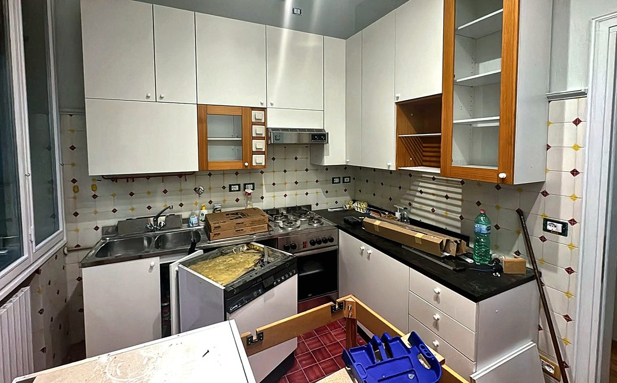 Cucina prima dell'intervento, con il vecchio top e gli elettrodomestici da sostituire
